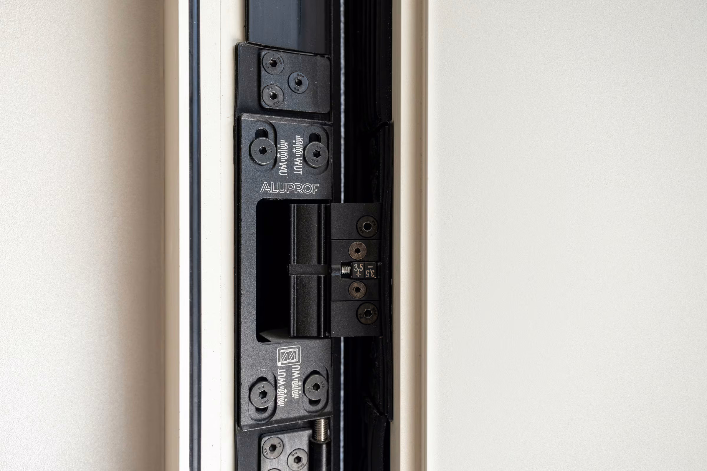 Detail of a metal locking mechanism mounted within the door frame.