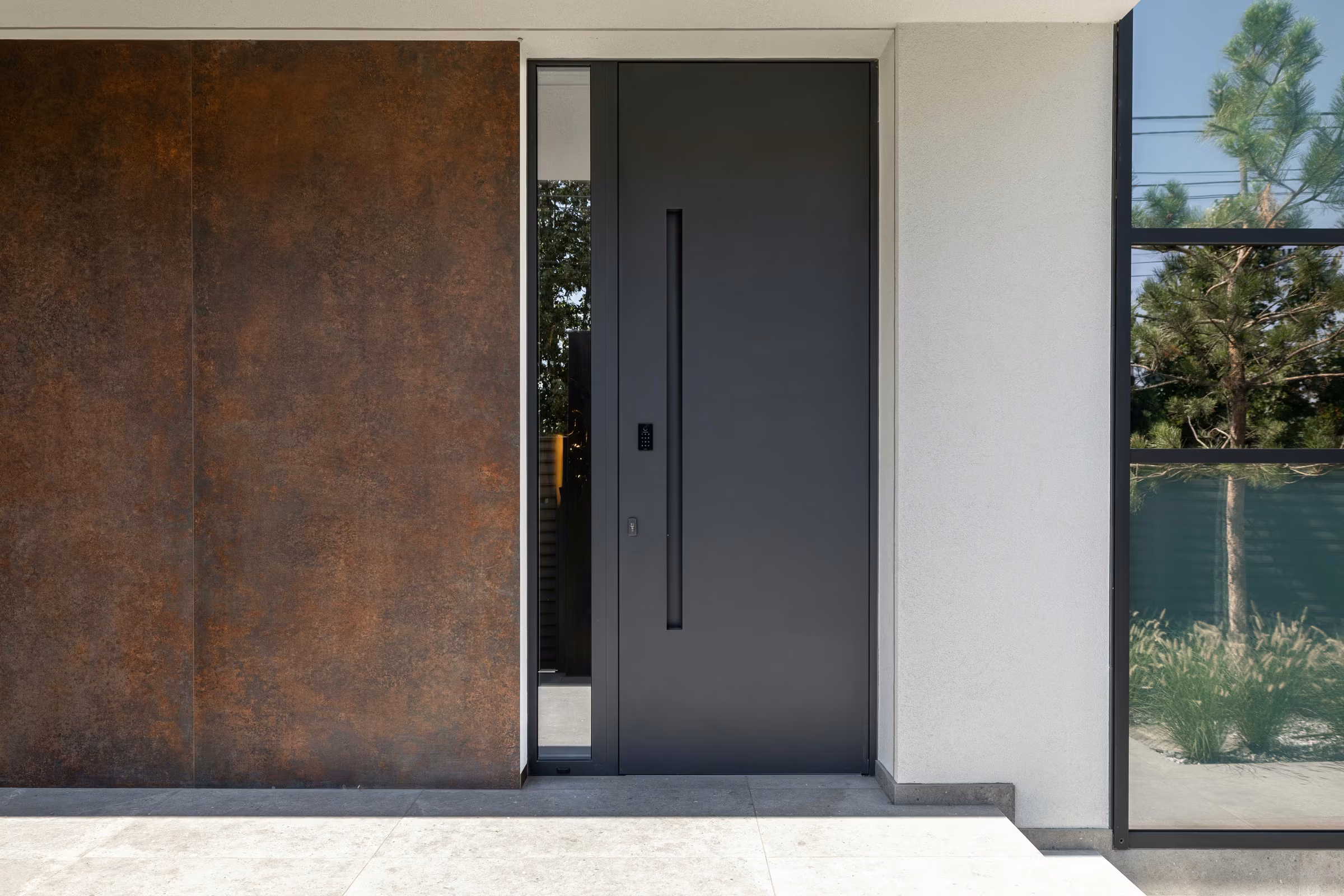 Contemporary entrance with a dark door, side glazing and a brown wall finish.