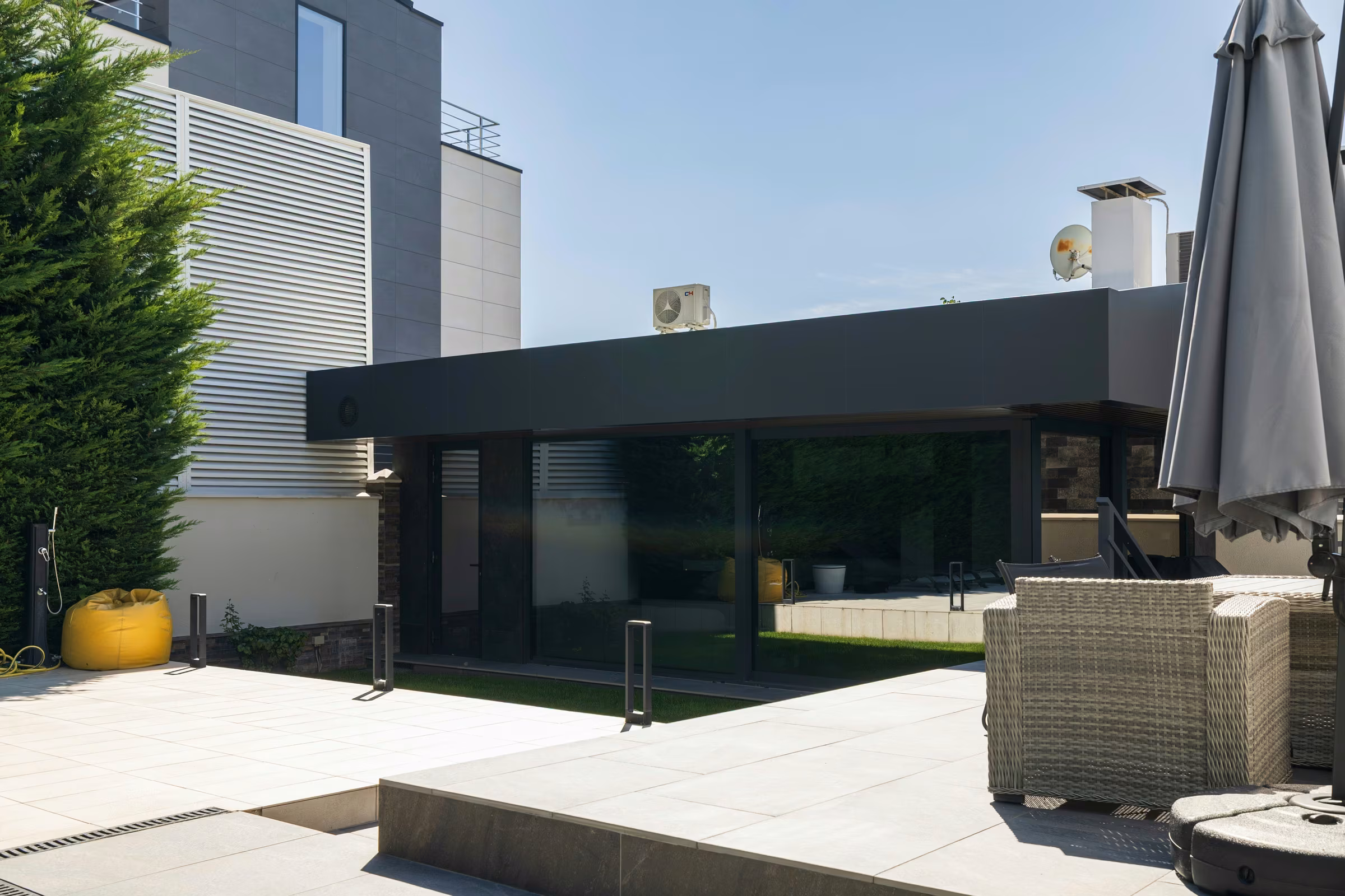 View of the terrace with glazed walls and dark window frames.