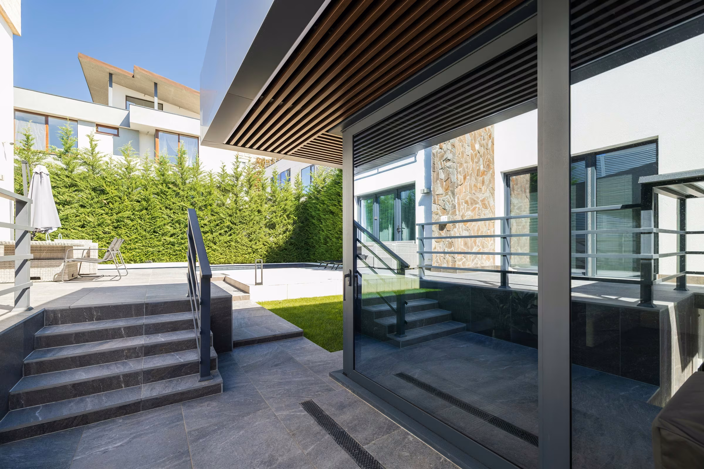 Exterior perspective of the terrace with panoramic glazing and open space in front of the building.
