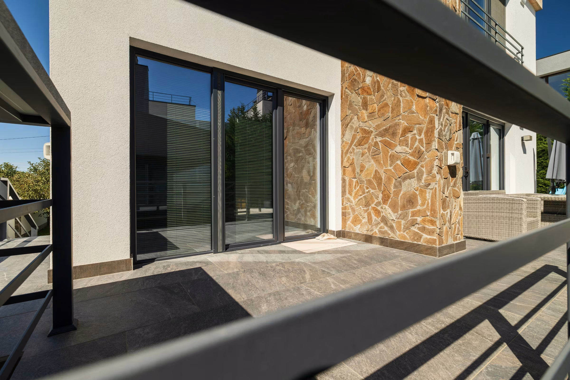 Panoramic terrace glazing with aluminium frames and joints between panels.