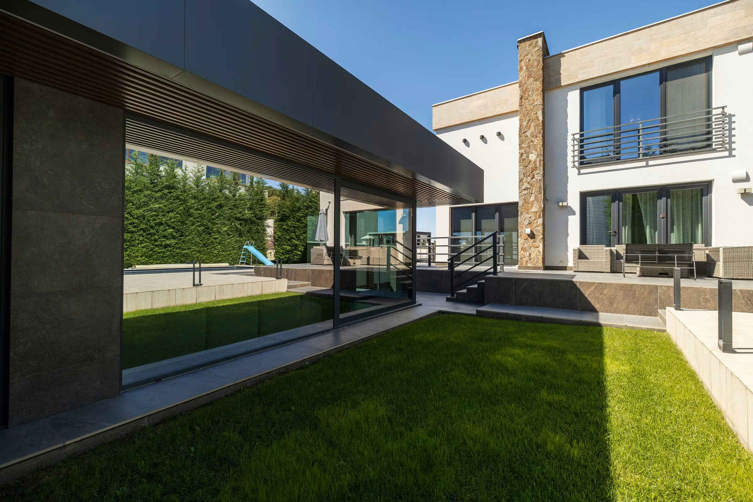Tall glazed surfaces integrated into the terrace with anthracite aluminium frames.