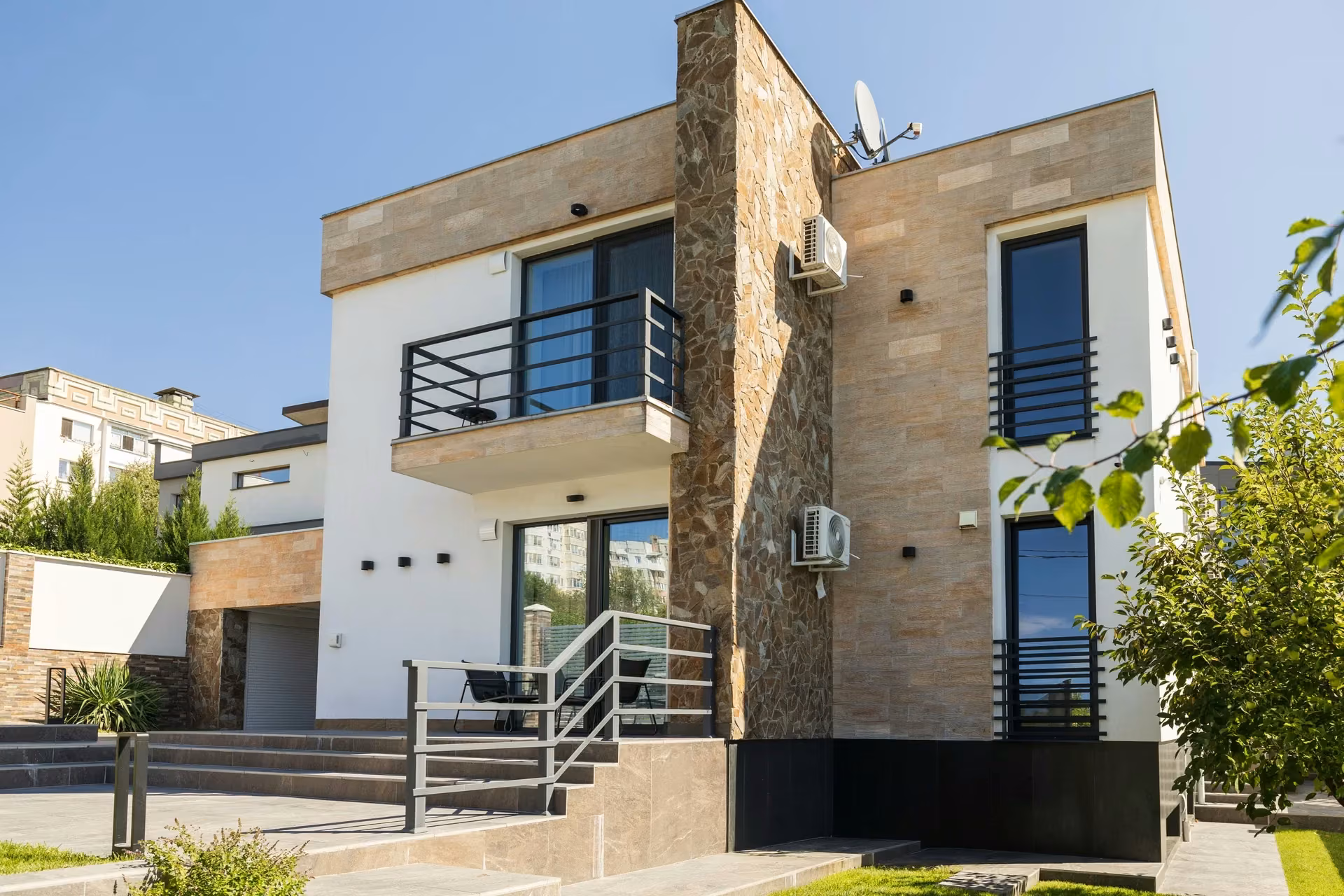 View of a corner of the house where dark window frames meet the stone-clad façade.