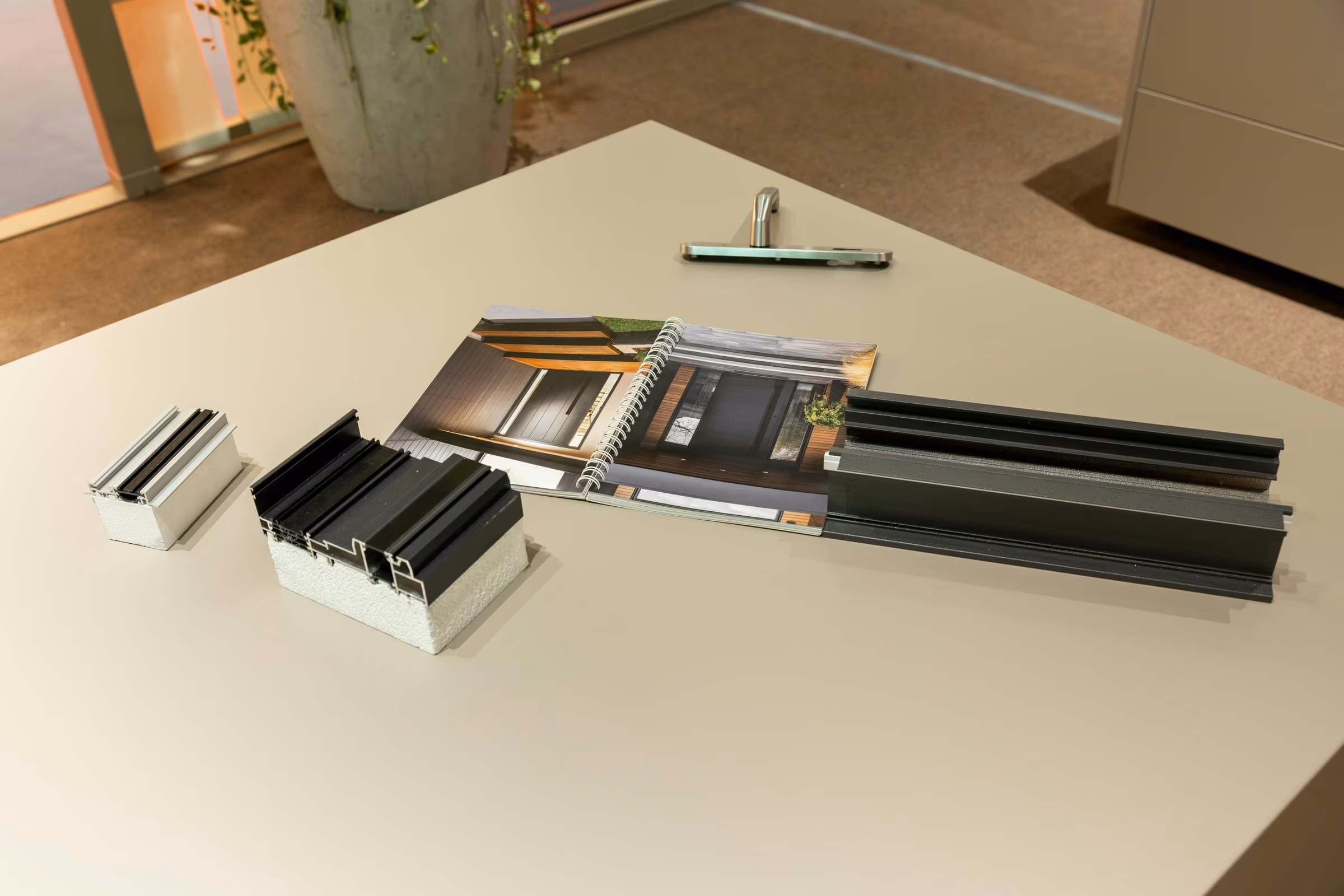 Aluminium profile samples and metal finishes displayed on a table at the Plastregal stand.