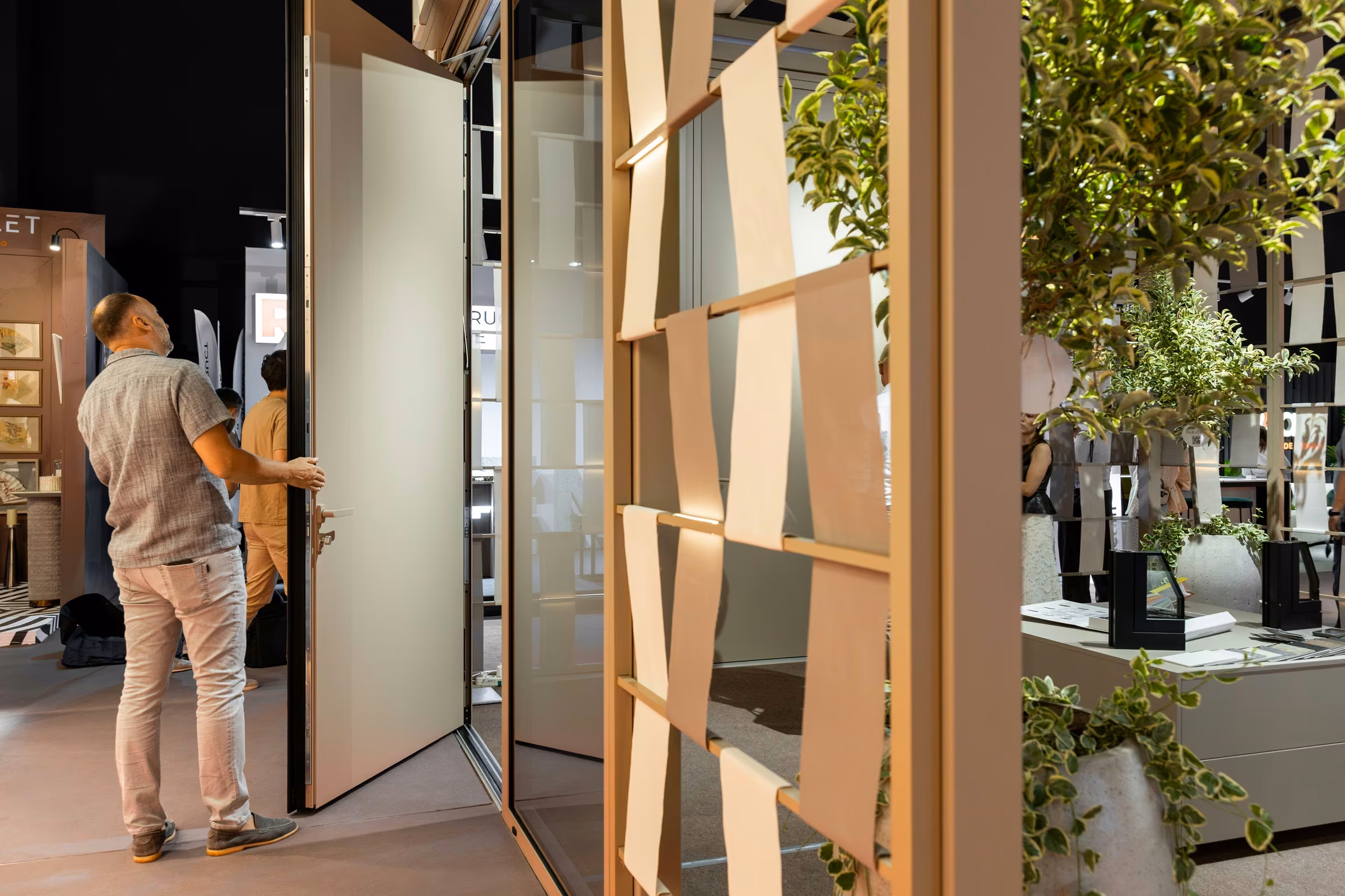 Visitor exploring the opening of a tall light-coloured panel door beside the timber structure.