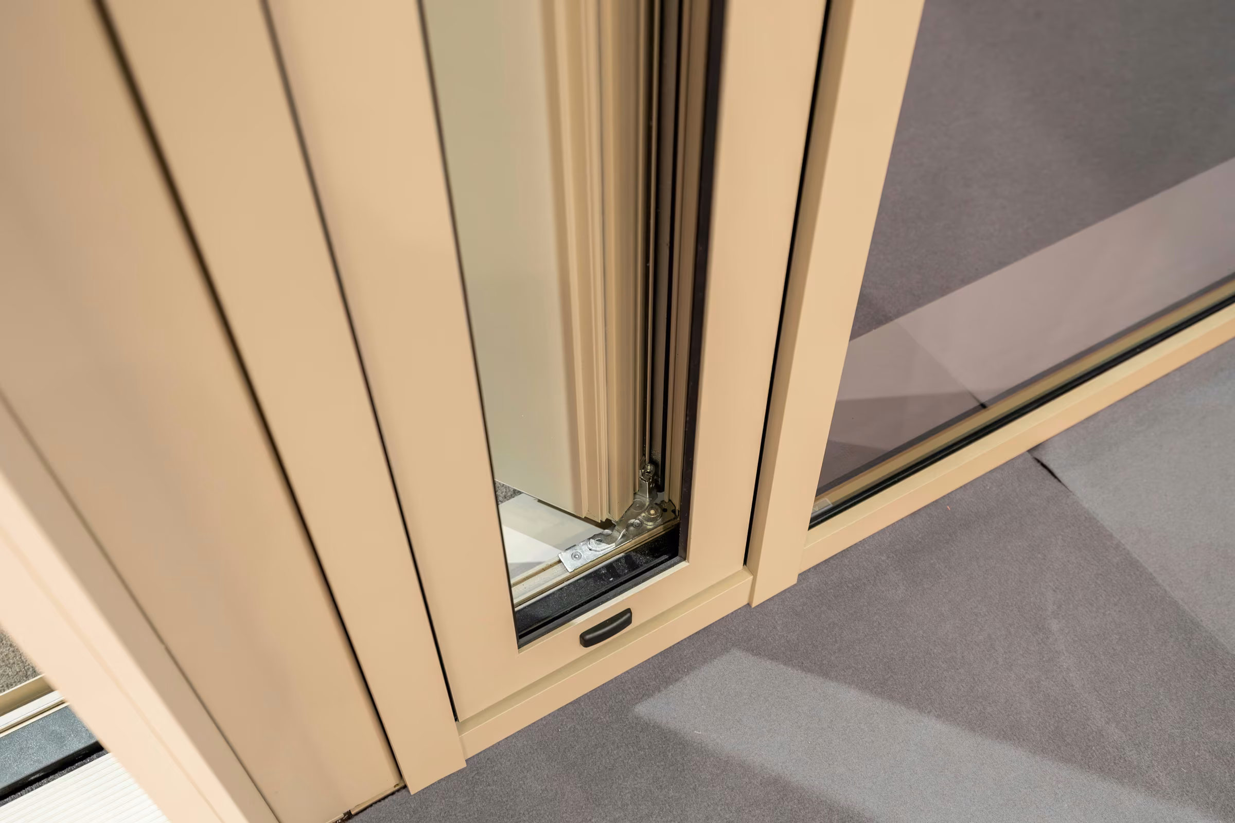 Lower detail of an open casement window with a light-coloured aluminium frame.